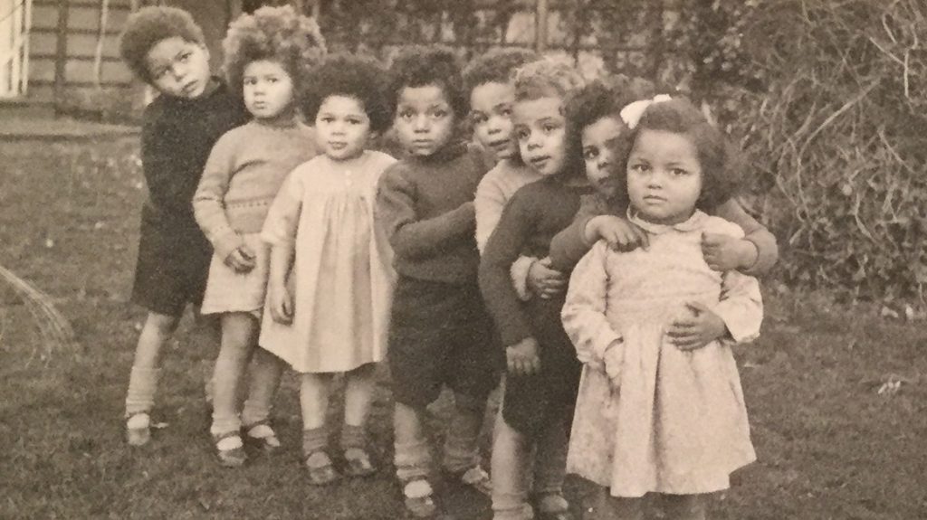 A sepia photo of young children standing in a line