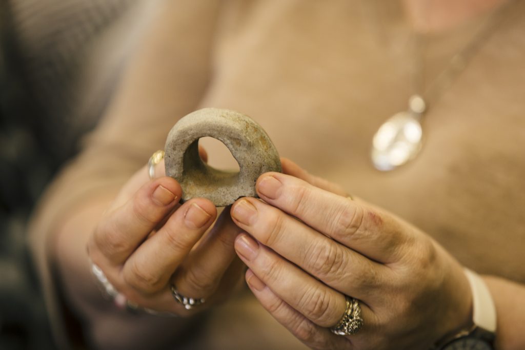 A person holds a small stone object