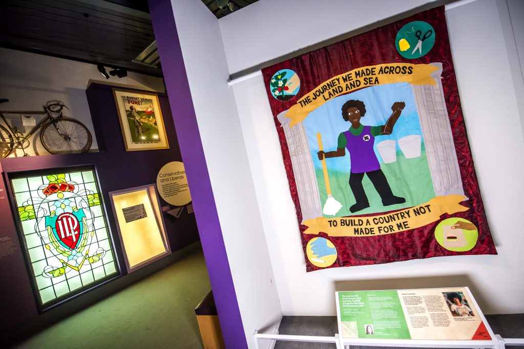 A banner at the People's History Museum, which reads 'The journey across land and sea to build a country not made for me'